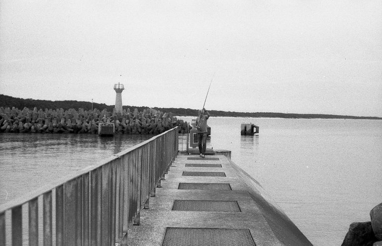 Wędkarz na główce portu w Kołobrzegu – fotografia z duszą nad Bałtykiem